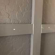 the corner of a wall with some white paint on it and two pieces of wood sticking out