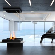 a piano sitting in the middle of a room next to a fire place and large windows