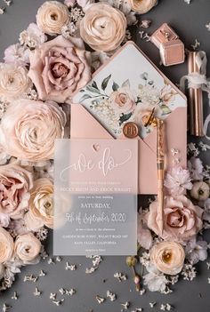 the wedding stationery is surrounded by flowers and confetti, such as peonies