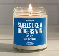 a candle that says smells like a dodger's win in front of a white background