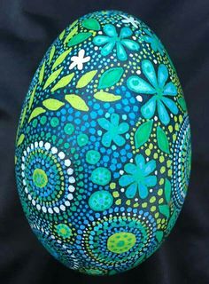 an egg painted with blue and green flowers