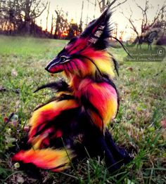 a stuffed animal sitting on top of a lush green field