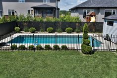 an empty swimming pool in the middle of a yard with fenced in areas around it