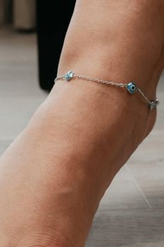 Enjoy the beautiful anklet with either a golden chain or a silver one. Available in both colors to maximize its wear. Finding a size poses a problem? Worry not, The chain is 7-8 inches in length, with an additional adjustable chain up to 5 cm. Secure the chain ends with a lobster claw closure. The chain is decorated with tiny Turkish evil eye beads to keep off any 'Nazar'. Designed with a minimalist style to give off the model vibes. Use it as a charm as well as a jewelry piece, completely two in one. 100% handmade with metal alloys and boosted with the evil eye charm beads. Evil Eye Beads, Evil Eye Protection, Turkish Evil Eye, Golden Chain, Charm Beads, Eye Beads, Evil Eye Charm, Anklet Jewelry