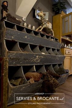 there is an old wooden rack with many items on it in the room that has wood floors and walls