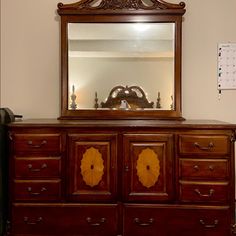 an antique dresser with a mirror above it