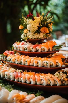 sushi platters are stacked on top of each other with flowers in the background