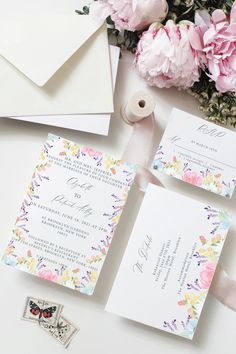 the wedding stationery is laid out next to flowers