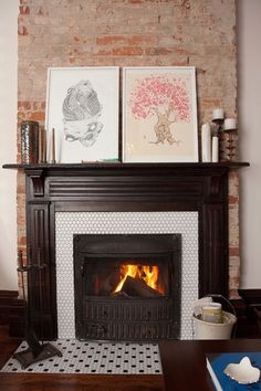 a fireplace with two pictures on top of it and a fire place in the middle