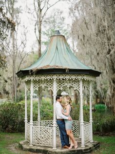 a man and woman standing in front of a gazebo