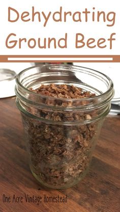 a glass jar filled with ground beef on top of a wooden table