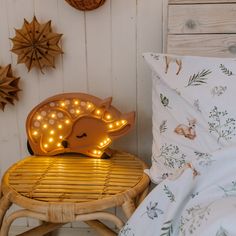 an animal shaped light up lamp sitting on top of a wooden stool next to a bed