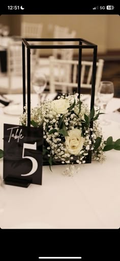 a table with flowers and a sign on it that says the number five is 5