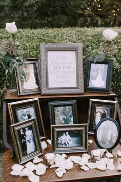 a table topped with framed pictures and flowers