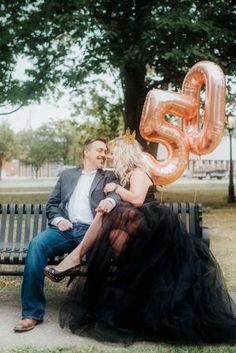 a man and woman sitting on a bench with the number six balloon in front of them