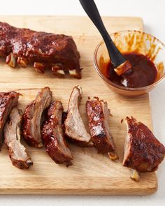 ribs on a cutting board with dipping sauce