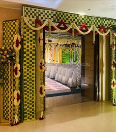 a decorated stage with white beds and red flowers on the headboard, in front of an open doorway