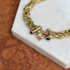 14KT yellow gold Byzantine weave necklace with cabochon sapphires end caps detailing, easy-to-use toggle ring clasp. Two styles in one necklace- wear the toggle in front or in the back! You can even hang a pendant off the toggle for added interest! Length: 18" Made in Italy Weight: 24.80 grams Toggle spring ring clasp measures: 11mm Endcaps: 15mm Chunky links measures: 9.5mm wide 14K toggle clasp (4) cabochon blue sapphires Elegant Gold Toggle Necklace With Gemstone, Formal Round Toggle Necklace, Formal Toggle Clasp Necklace, Timeless Toggle Necklace With Toggle Clasp For Formal Occasions, Timeless Toggle Clasp Necklace For Formal Occasions, Toggle Clasp Necklace, Pearl Accessories, White Gold Bracelet, Rose Gold Pendant