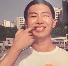 a man holding an orange in front of his face