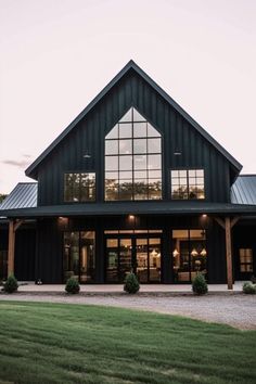 a large black building with lots of windows on it's sides and grass in front of it