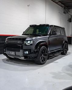 a black suv parked in a garage next to a wall