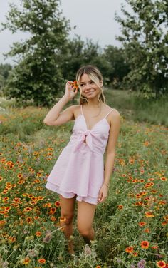 a woman standing in a field with flowers