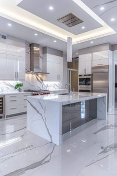 a large kitchen with white marble counter tops and stainless steel appliances, along with recessed lighting