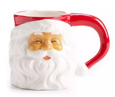 a red and white coffee mug with a santa claus face on it's side