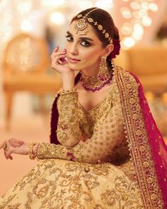 a woman in a bridal outfit sitting on the floor with her hand under her chin