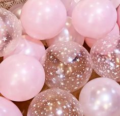 many pink and white balloons with stars on them