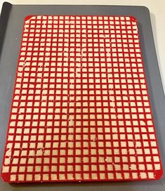 a red and white checkered tray sitting on top of a counter next to a knife