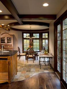 a kitchen with wood floors and large windows