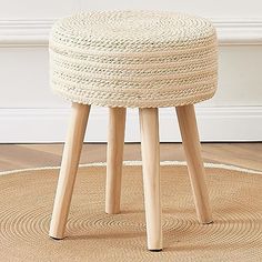 a round stool with wooden legs on a rug