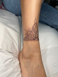 a woman's foot with a tattoo on her left ankle and flowers on the other side