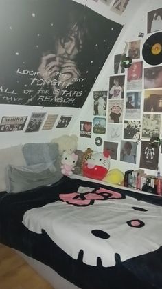 a bedroom with posters on the wall and a hello kitty bed in front of it