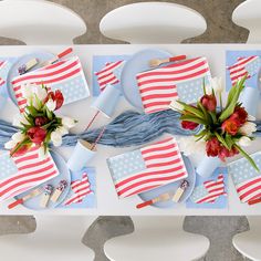 the table is set with plates, napkins and flowers on them for an american flag theme