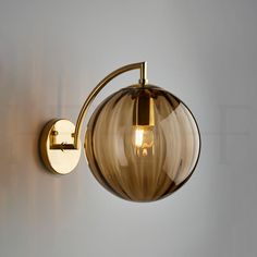 a light that is on the wall next to a white wall with a glass ball