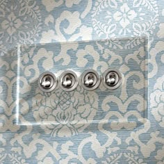 three knobs are on the wall in front of a blue and white patterned background