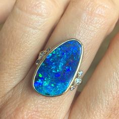 How much do we love this incredible solid Australian Opal? Emily is OBSESSED with finding the best Opals and over the years has found some incredible specimens and this one is no exception. We set her in 14k yellow gold with a gold freeform band and a bevy of brilliant cut white diamonds on its shoulders. Approx stone size: 23mm x 13.5mm Opal ct weight: 9.9cts Diamond ct weight: .26cts This one of a kind piece is handmade in Emily's Hudson Valley studio. This piece is in stock and currently a si Australian Opal Ring, Blue Opal Ring, Diamonds Ring, Local Jewelry, Australian Opal, Hudson Valley, Blue Opal, White Diamonds, Opal Rings