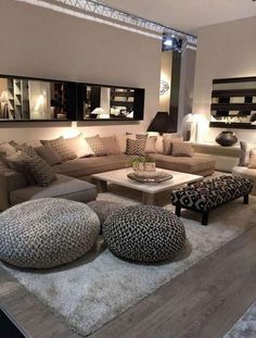 a living room filled with lots of couches and pillows on top of a wooden floor