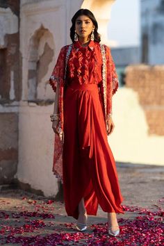 Ruby red cape with feather print and pearl, dori embroidered cutwork border. Paired with ruffle shirt and draped skirt.
Components: 3
Pattern: Printed, Embroidery
Type Of Work: Feather, pearl, dori
Neckline: Cape: Open, Shirt: Spread collar
Sleeve Type: Flared sleeves
Fabric: Flat Chiffon, Dola Silk, Organza
Color: Red
Other Details: 
Cutwork border
Lace embroidered panel
Occasion: Sangeet - Aza Fashions Feather Cape, Printed Embroidery, Border Lace, Open Shirt, Red Cape, Red Flats, Draped Skirt, Ruffle Shirt, Feather Print