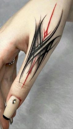 a woman's hand with a black and red tattoo on it