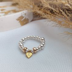 Gold heart stretchy ring *925 sterling silver balls *24K gold vermeil heart charm *Elasticated - made with high quality elasticated string *Hypoallergenic *Option to personalise (See sizing & personalisation information below) SIZING: Please note these rings come on elasticated string in 3 different sizes: *Small - (suitable for ring sizes J-M) *Medium - (suitable for ring sizes N-Q) *Large - (suitable for ring sizes R-U) (Smaller or larger sizes can be made - leave measurement or ring size at checkout) If you're unsure of your ring size you can measure your finger using a piece of string: -Wrap the string around the base of your finger. -Mark where the string ends with a pen. -Place the measured string against a ruler with the area marked on your right. -Select any size when purchasing bu Cheap Silver Stackable Rings For Gift, Cheap Stackable Metal Rings, Mixed Metal Ring, Leopardskin Jasper, Stretchy Rings, Mixed Metal Rings, Friend Rings, Gold Heart Ring, Silver Heart Ring