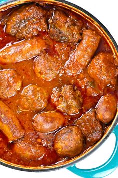 a blue pot filled with meat and sauce