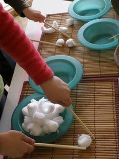 two people are making marshmallows in blue bowls on bamboo mat with chopsticks