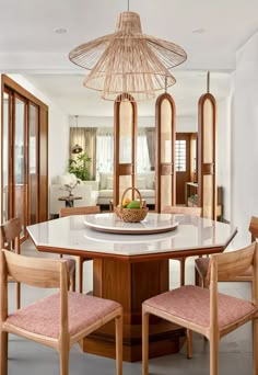 a dining room table with chairs and a basket on it's centerpiece in the middle