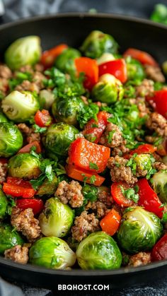 brussel sprouts with tomatoes, peppers and ground meat in a skillet