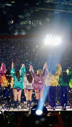 a group of people standing on top of a stage with confetti in the air