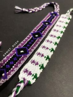 a purple and green beaded lanyard on a black surface with white thread,