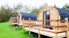 several small wooden cabins are lined up on the grass